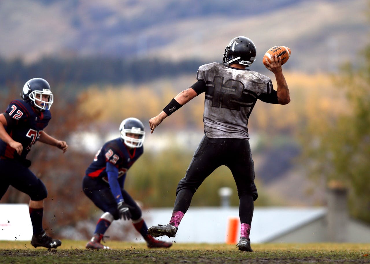Athletes competing in an intense American football game, showcasing teamwork and athleticism on the field.